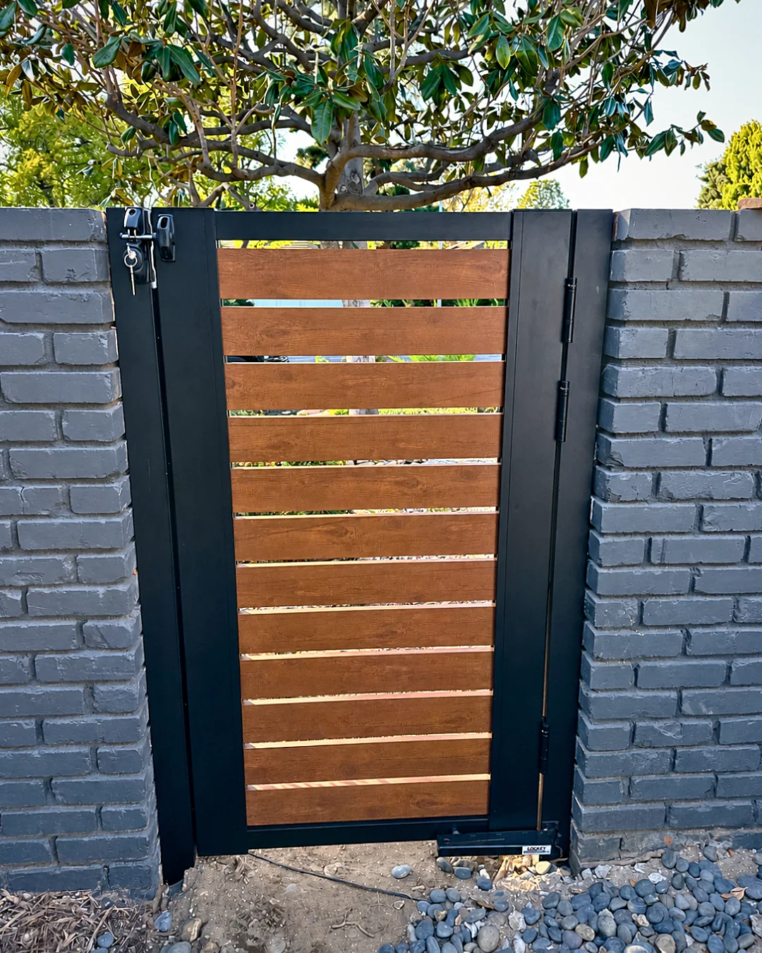 ALU40 wood grain gate between brick pillars
