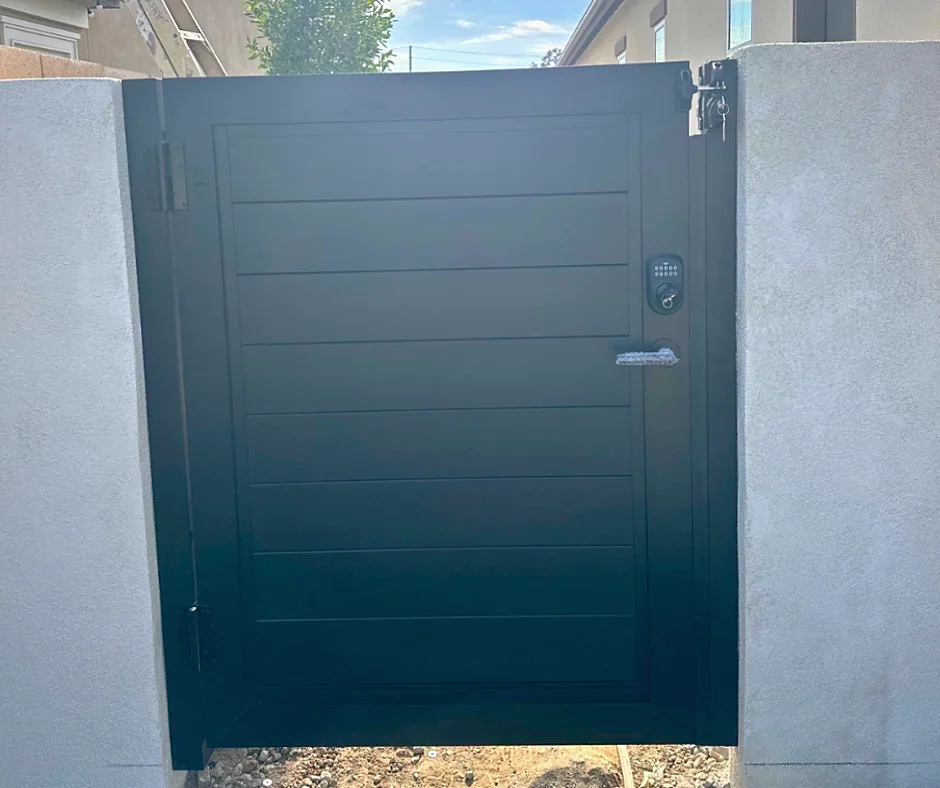 ALU60 full privacy black gate between stucco walls