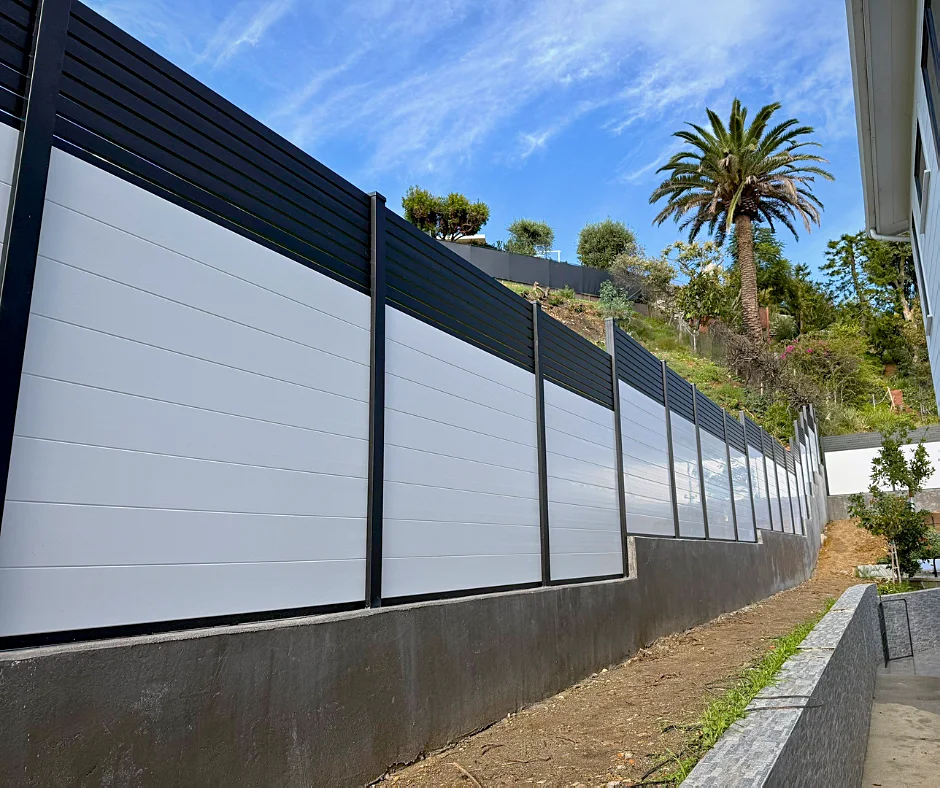 White ALU60 T&G privacy fence with a black slat top below a hillside