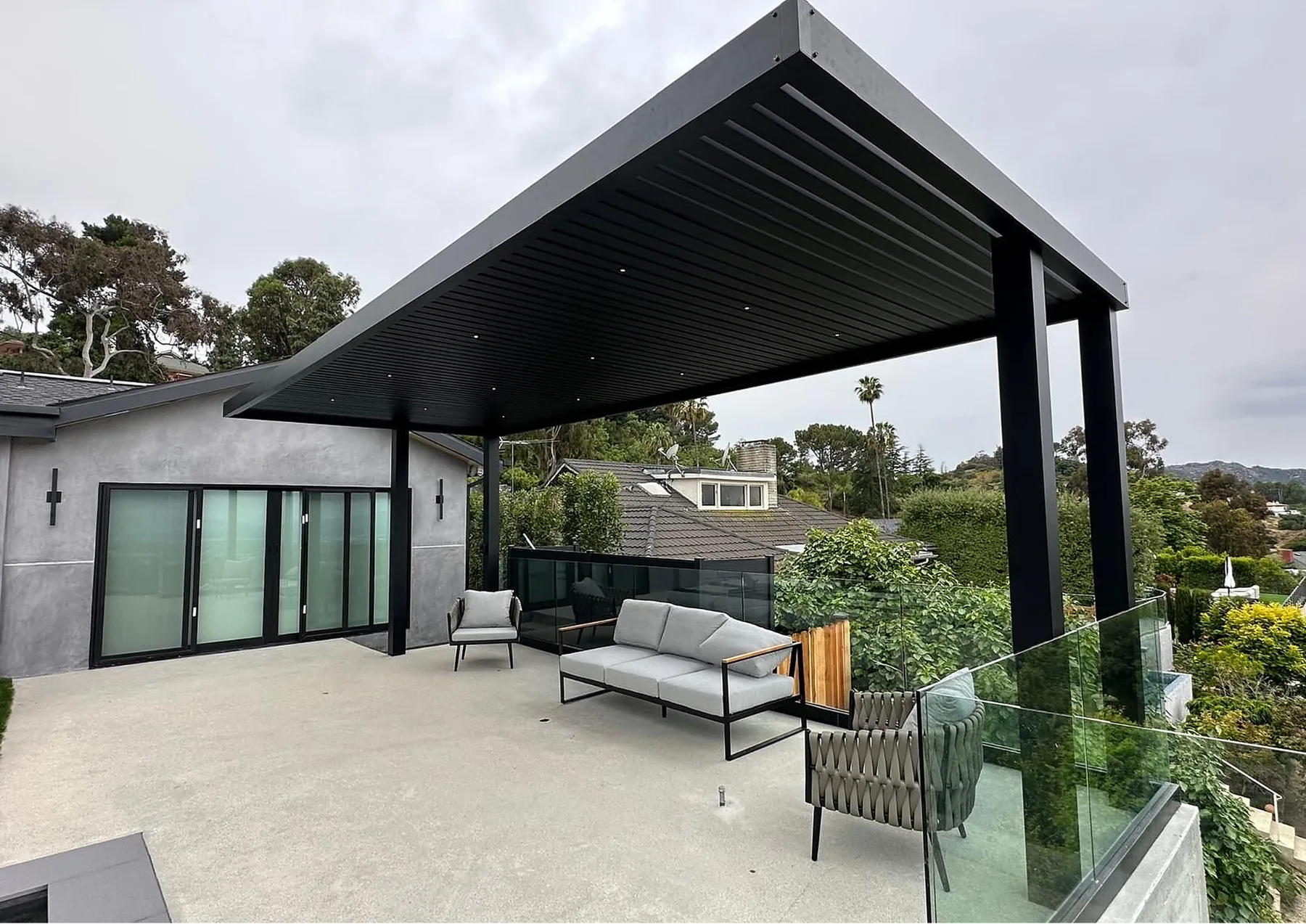 ALU FLOAT cantilever slat roof patio cover on a hillside deck