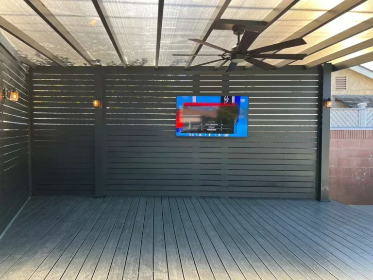 Aluminum beam patio cover with clear roof panels and slat privacy walls