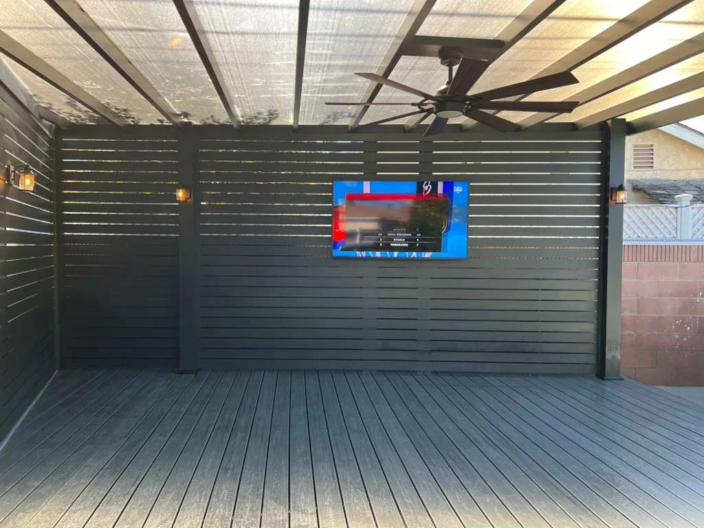 Aluminum beam patio cover with clear roof panels and slat privacy walls