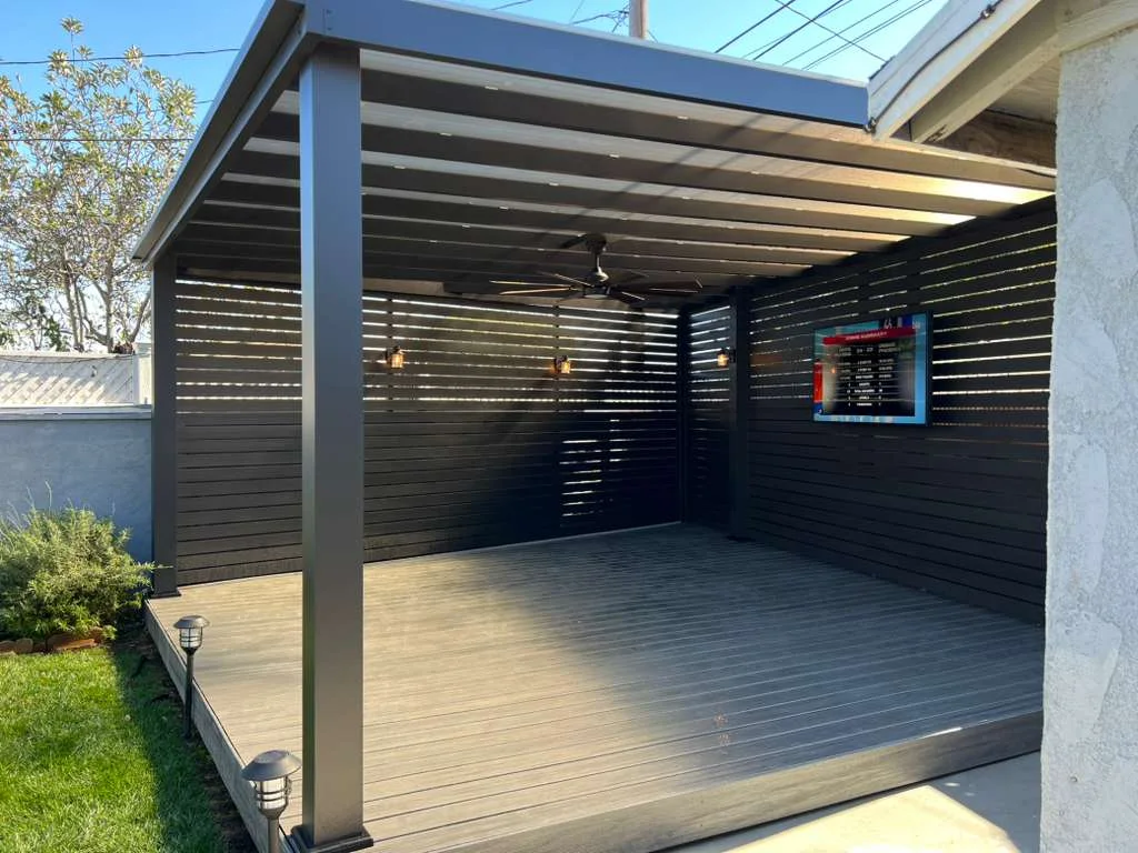 Aluminum beam patio cover with clear roof panels and slat privacy walls