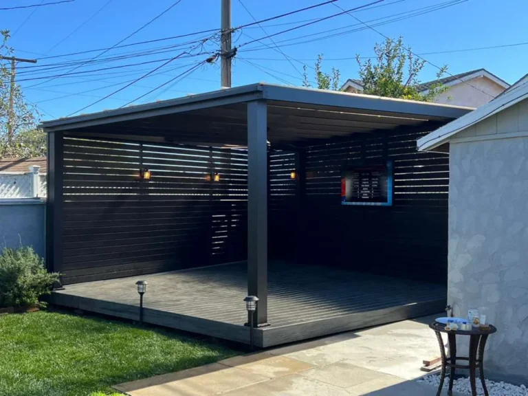 Aluminum beam patio cover with clear roof panels and slat privacy walls
