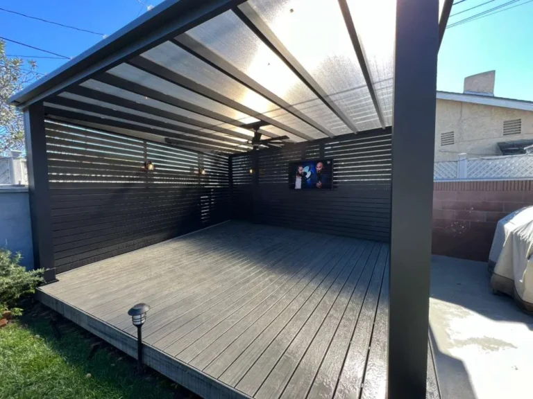 Aluminum beam patio cover with clear roof panels and slat privacy walls