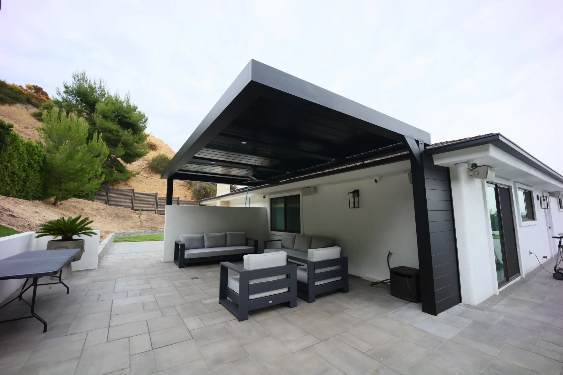 Black aluminum patio cover over a tiled patio