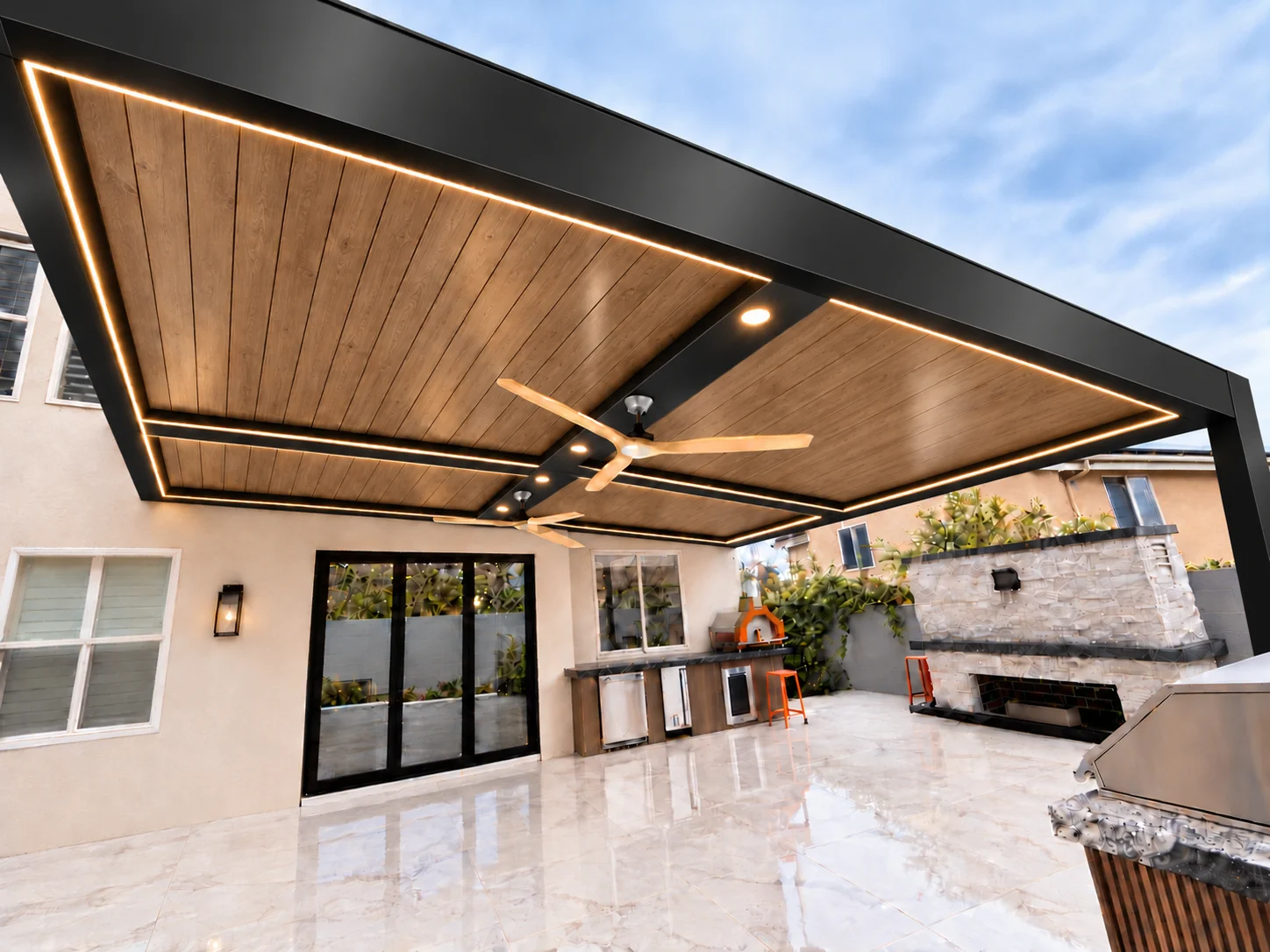 ALU FORTIS patio cover with an Ipe woodgrain roof, black frame, LED perimeter lighting and ceiling fan