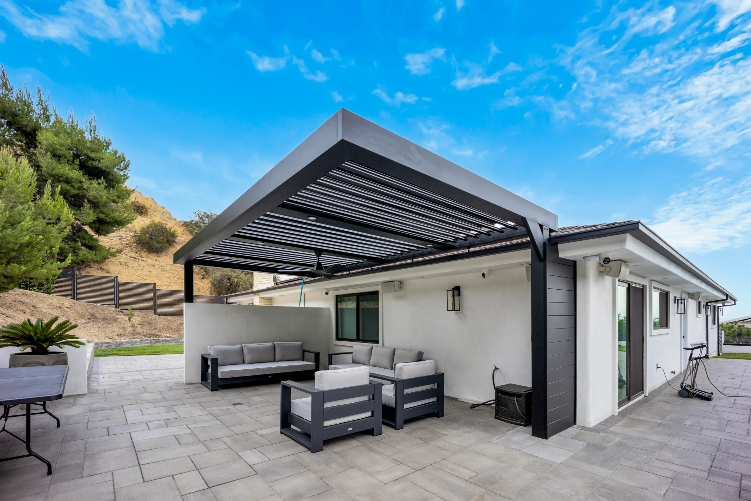 Black automatic louvered patio cover over a hillside patio in Burbank, CA