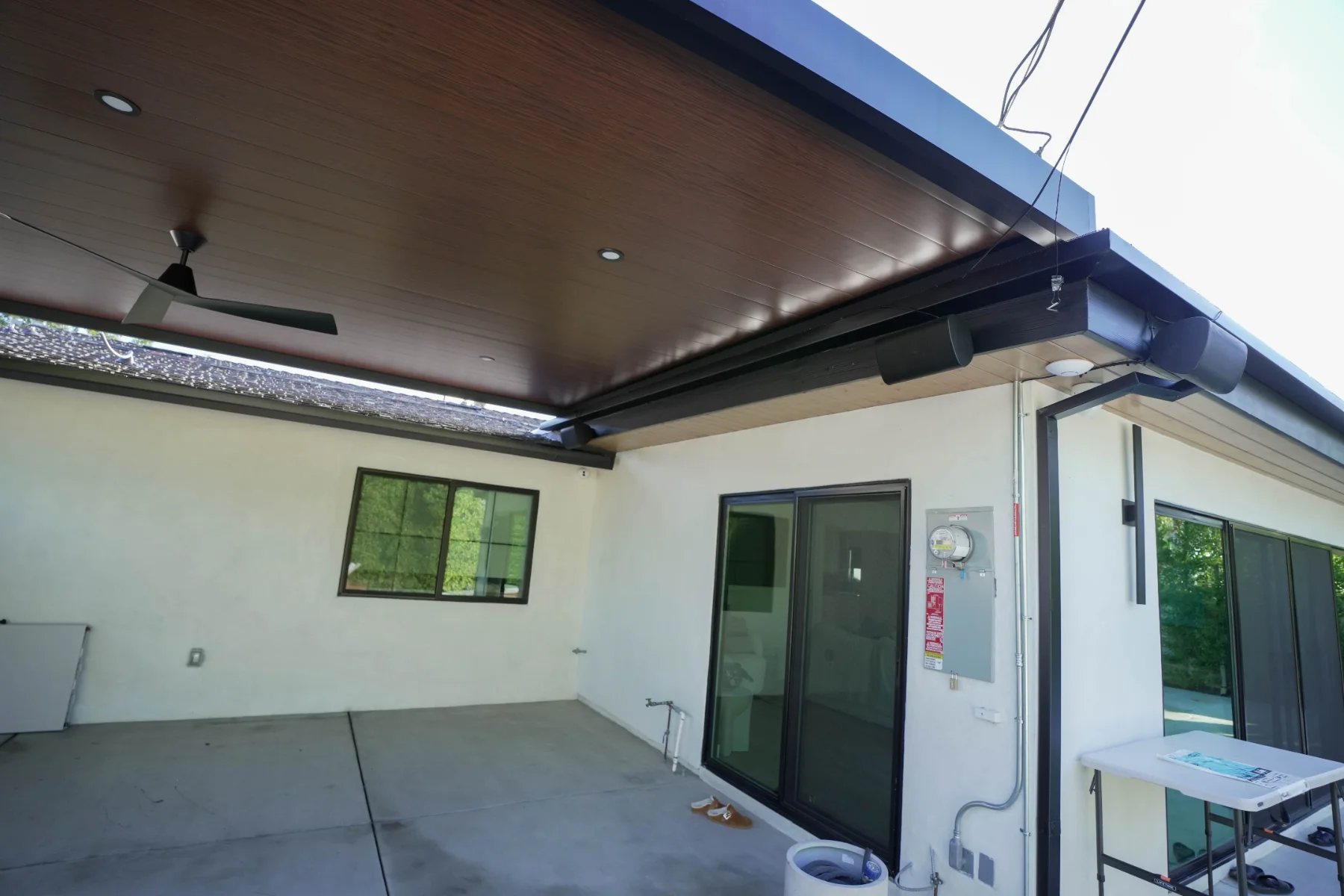 Woodgrain insulated patio cover with ceiling fan