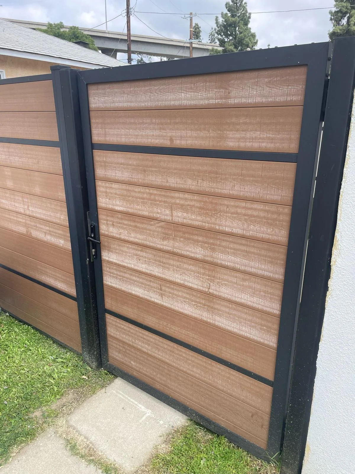 Not an Aluglobus product. Field photo: composite gate with uneven fading on the boards