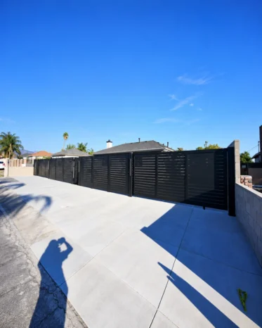 Architectural matte black horizontal slat aluminum fencing complementing modern Miami home exterior.