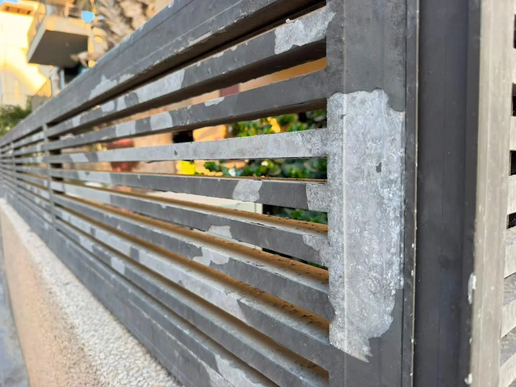Not an Aluglobus product. Field photo: standard powder coat peeling off an aluminum fence